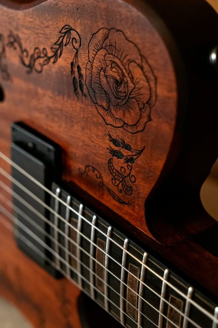 A close up of a guitar with a rose design on it